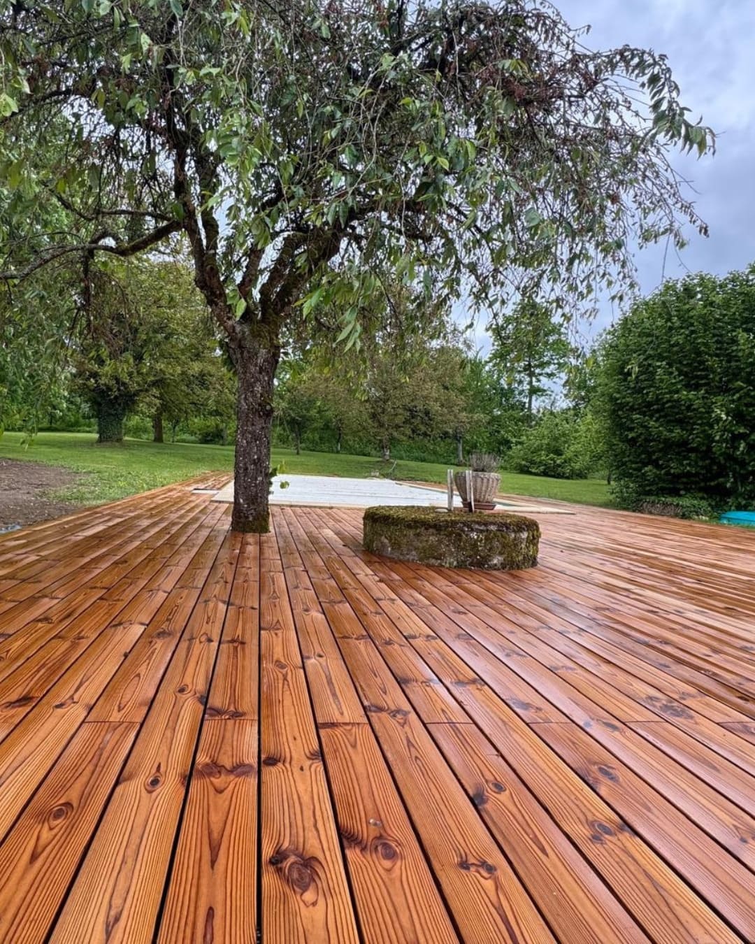 Grande terrasse en bois Thermopin de 100m² intégrée dans un jardin à Delme